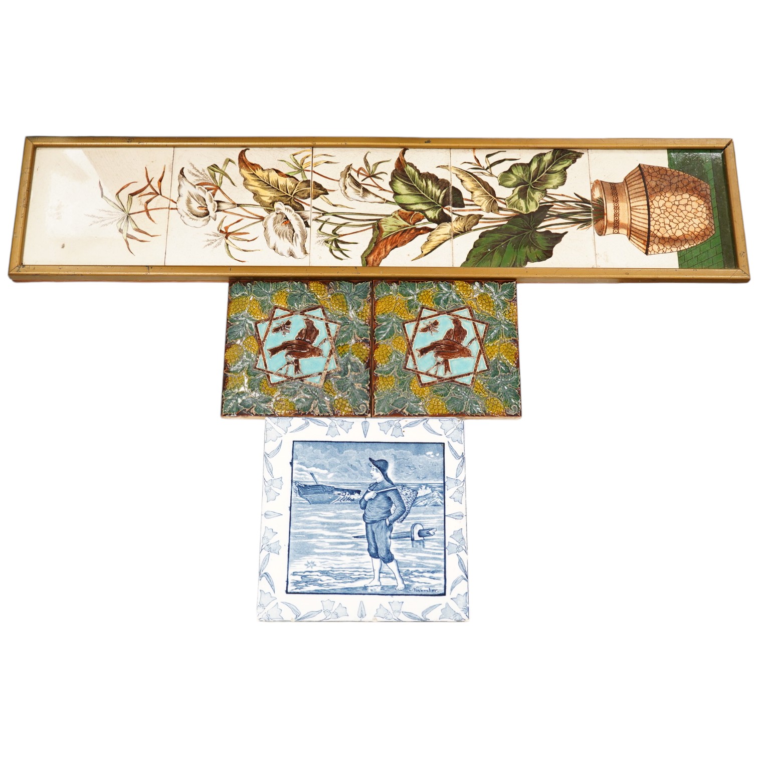 A Victorian five tile framed panel, a Wedgwood November tile and two majolica tiles, five tile panel 80cm high. Condition - worn and crazed